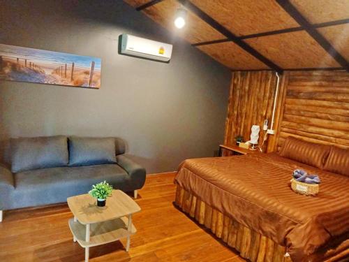 a hotel room with a bed and a couch at Kohmook Nurse House in Koh Mook
