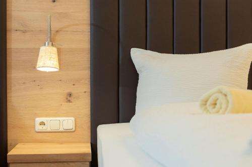 a bedroom with a white bed and a light switch at Appartement Mühlkogel mit Indoorpool und Sauna in Bad Goisern