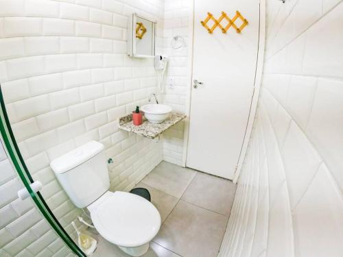 ein weißes Bad mit einem WC und einem Waschbecken in der Unterkunft Meu Lar Meu Mar 1 in Ubatuba