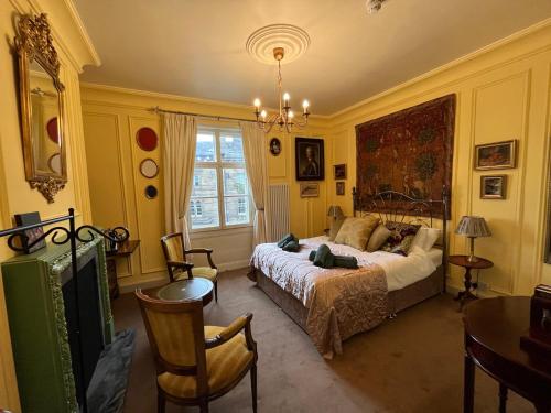 a bedroom with a bed and a table and chairs at Chez Vivienne in Ilkley