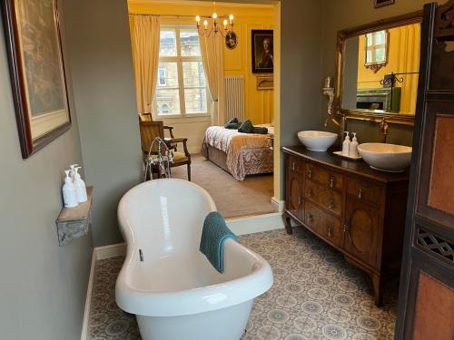 a bathroom with a bath tub and a sink at Chez Vivienne in Ilkley