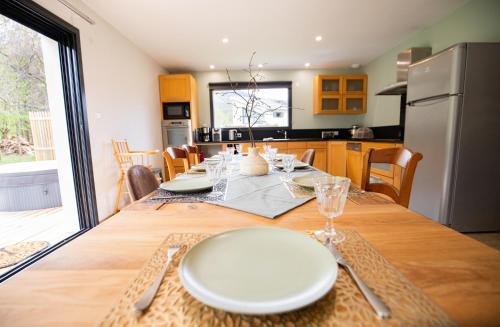 une cuisine et une salle à manger avec une table avec des assiettes blanches dans l'établissement Villa à 5mn d'Ax les Thermes, à Perles-et-Castelet