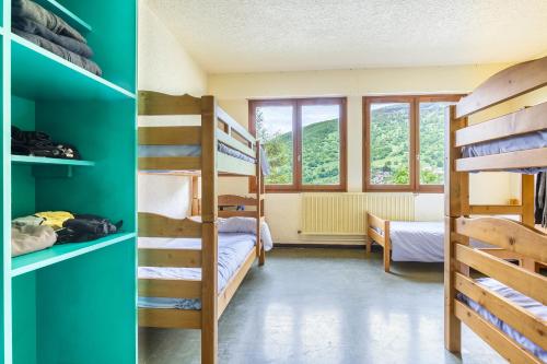 a room with two bunk beds and a room with a window at Auberge de jeunesse HI Valmeinier in Valmeinier