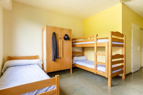 a bedroom with two bunk beds and a bunk bed at Auberge de jeunesse HI Valmeinier in Valmeinier