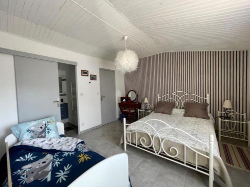 a bedroom with a bed and a chair in it at Charmante maison / Proche du lac de Casteljaloux in Casteljaloux