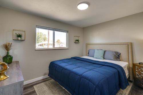 a bedroom with a bed with blue sheets and a window at Quiet Pueblo Home with Pool Table, 5 Mi to Downtown! in Pueblo