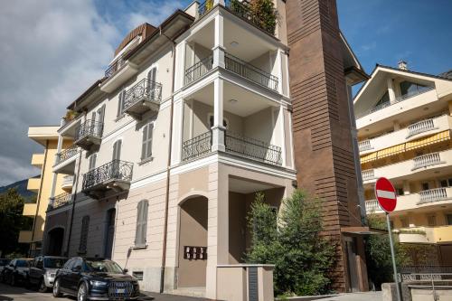 a white building with balconies and cars parked outside at Residenza Diaz in Domodossola