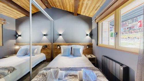 two beds in a room with two windows at Nouveau ! Chalet pied des pistes in Champagny-en-Vanoise