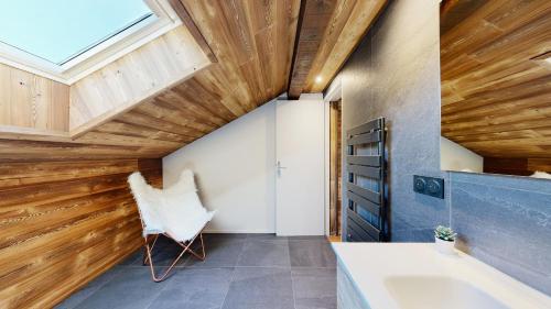 a bathroom with a wooden ceiling and a tub and a chair at Nouveau ! Chalet pied des pistes in Champagny-en-Vanoise