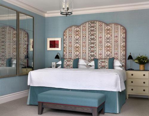 a bedroom with a large bed with a large headboard at The Soho Hotel, Firmdale Hotels in London