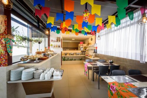 a restaurant with colorful flags hanging from the ceiling at Hotel Mais1 in Campina Grande
