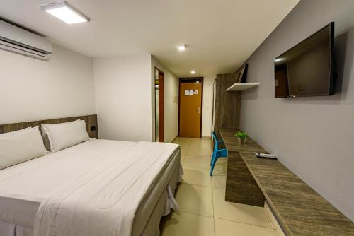 1 dormitorio con 1 cama y TV de pantalla plana en Hotel Mais1, en Campina Grande