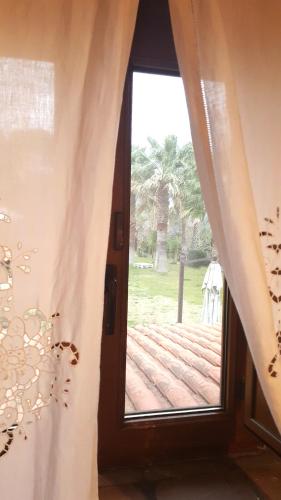 a window with a view of a wooden deck at Il Casale Del Sogno in Ardea