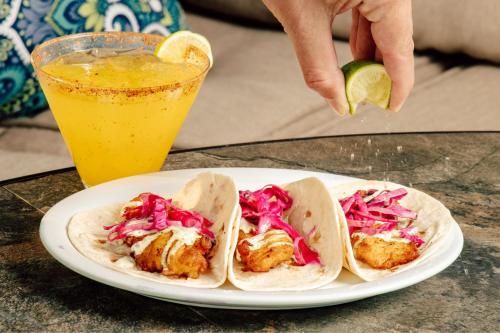 a plate with three tacos on a table with a drink at Residence Inn by Marriott Cincinnati Downtown/The Phelps in Cincinnati
