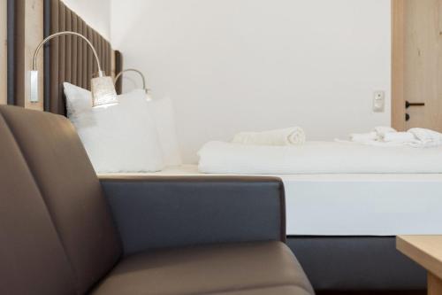 a desk with a chair next to a bed at Appartementhaus Dachsteinblick mit Indoorpool und Sauna in Bad Goisern