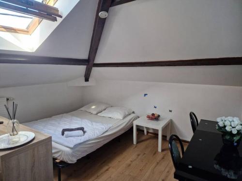 um pequeno quarto com uma cama no sótão em 5 verrerie em Chalon-sur-Saône