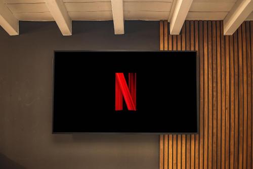 a television screen with a red letter on a wall at Luxury industrial apt vicino al centro con garage in Brescia