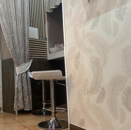 a bar stool in front of a wall with a wallpaper at b&b ERCOLANO Scavi in Ercolano