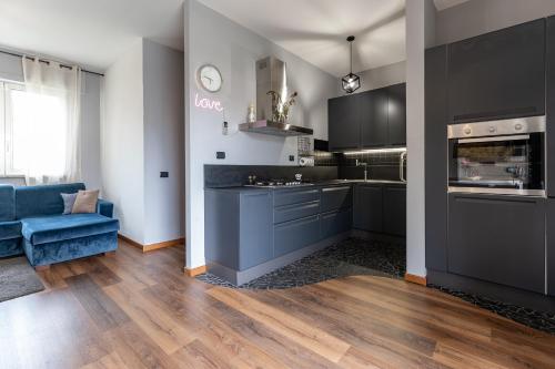 a kitchen with black cabinets and a blue couch at La casa di Vittoria in Arona