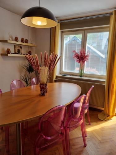 a dining room table with pink chairs around it at Sax Pub Hostel Ljubljana in Ljubljana