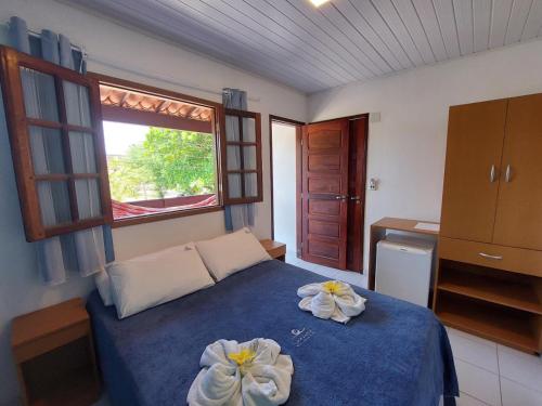 a bedroom with a blue bed with two flowers on it at Pousada Lua Azul in Porto De Galinhas