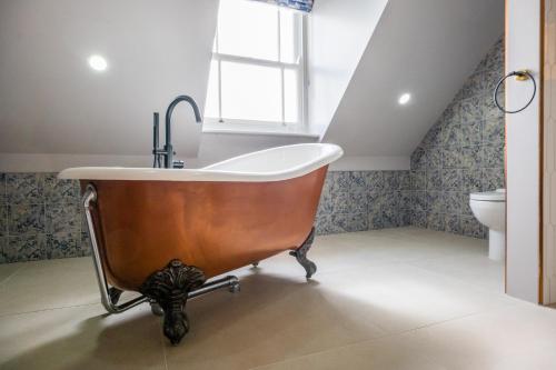 a bath tub with a sink in a bathroom at The Sheep and Penguin in Wells