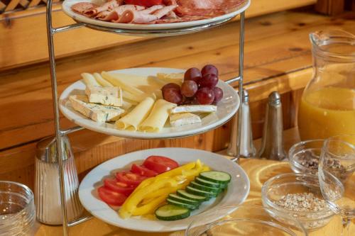 two plates of cheese and vegetables on a table at Appartementhaus Dachsteinblick mit Indoorpool und Sauna in Bad Goisern