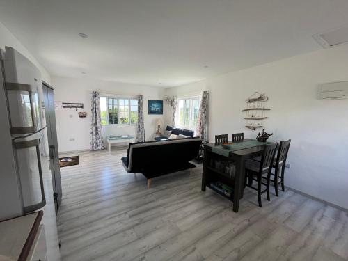 a living room with a table and a couch at Waves Villa Guesthouse in Kingstown