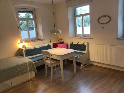 una habitación con una mesa y sillas y una cama en maison milabee, en Altenkunstadt