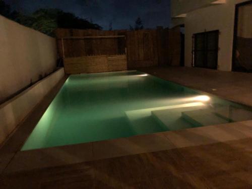 a swimming pool in a backyard at night at NDARI in Siendou