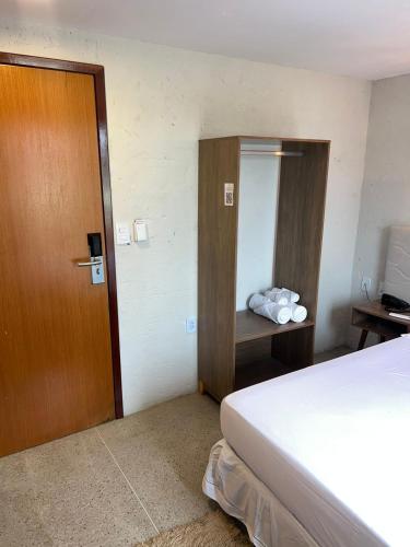 a hotel room with a bed and a wooden door at NOAH Rústico Hotel in Bôca da Mata