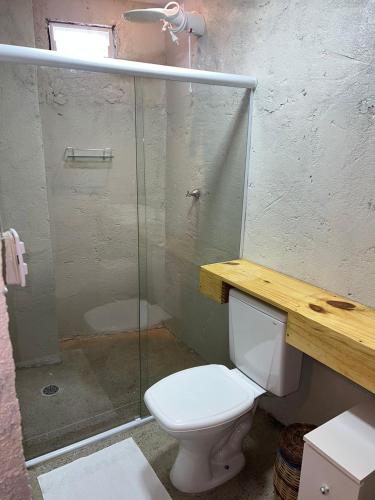 a bathroom with a toilet and a glass shower at NOAH Rústico Hotel in Bôca da Mata