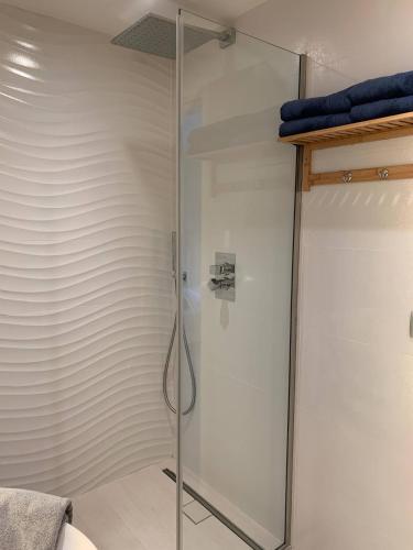- une cabine de douche avec une porte en verre dans la chambre dans l'établissement Ô Béatrice Croisette, à Cannes