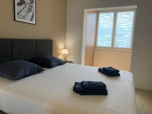 - un grand lit blanc avec 2 serviettes bleues dans l'établissement Ô Béatrice Croisette, à Cannes