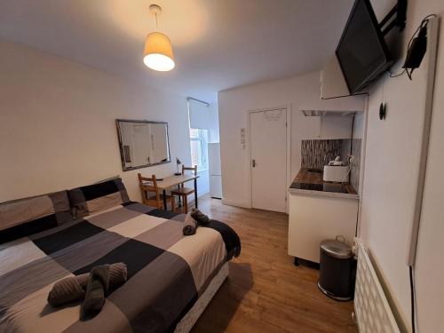 a bedroom with a large bed and a kitchen at Private self-contained studio close to Hampstead, Golders Green & Camden Town in London