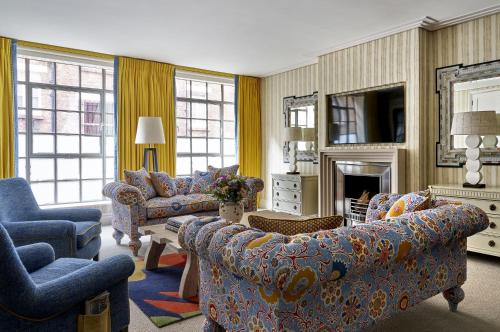 a living room with couches and chairs and a fireplace at The Soho Hotel, Firmdale Hotels in London