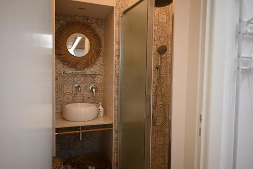 een badkamer met een wastafel en een spiegel bij Faliero Room in Canosa di Puglia