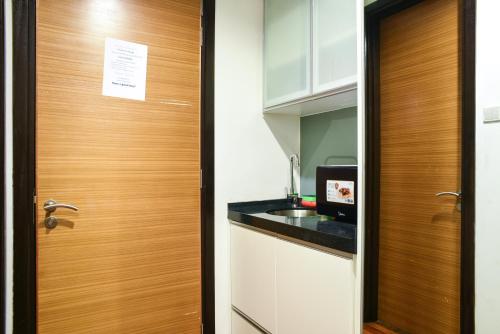a kitchen with a wooden door and a sink at BBHomes at Casa Residency KL in Kuala Lumpur