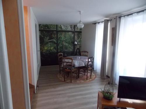 une salle à manger avec une table et des chaises et une fenêtre dans l'établissement Maison Sweet Cabana plein centre, à Cherbourg en Cotentin