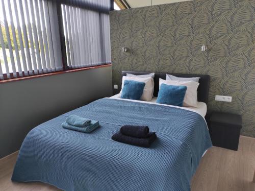 een slaapkamer met een blauw bed met 2 handdoeken erop bij Au Simply in Francorchamps