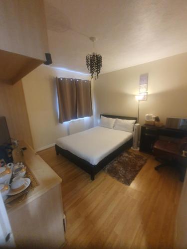 a bedroom with a bed and a table and a desk at Double size and Single room in Barking in Barking