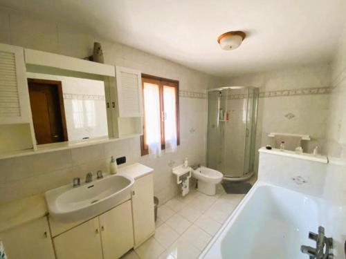 uma casa de banho com uma banheira, um lavatório e um WC. em La casa del Mike em Borgo a Mozzano