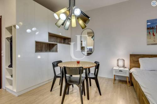 a dining room with a table and chairs and a bed at Geneva: A charming patio studio with private parking! in Sofia