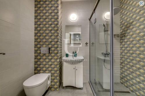 a bathroom with a toilet and a sink and a shower at Geneva: A charming patio studio with private parking! in Sofia
