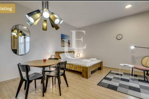 a room with a bed and a table and chairs at Geneva: A charming patio studio with private parking! in Sofia