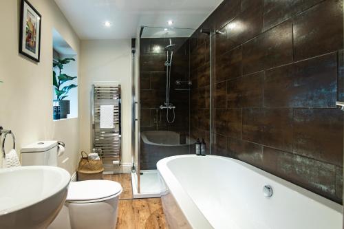 ein Badezimmer mit einer Badewanne, einem WC und einem Waschbecken in der Unterkunft The Marmot in Harrogate