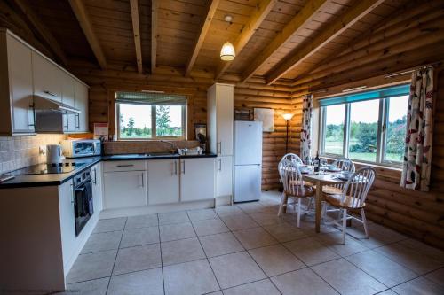 una cocina con mesa y sillas en una cabaña en Partridge Lodge en Selby