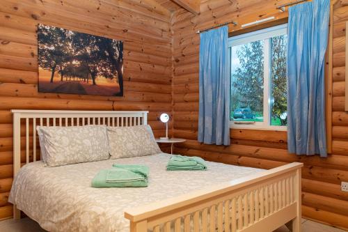 una camera con un letto in una baita di tronchi di Partridge Lodge a Selby