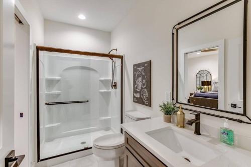 a bathroom with a toilet and a sink and a mirror at Luxury Estate with Stadium TDJ Views Sleeps 20 in South Bend
