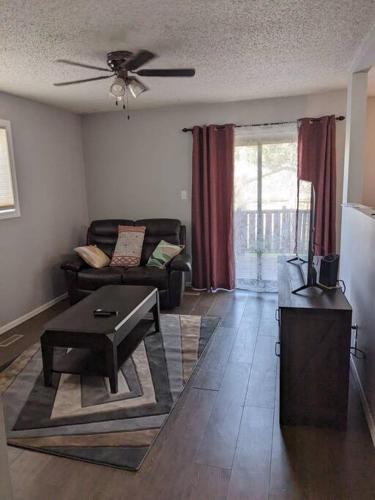 uma sala de estar com um sofá e uma mesa em Bi-Level Suite in Saskatoon em Saskatoon